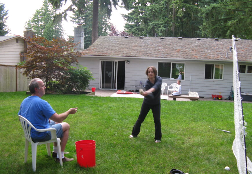 People playing badminton in a backyard.
