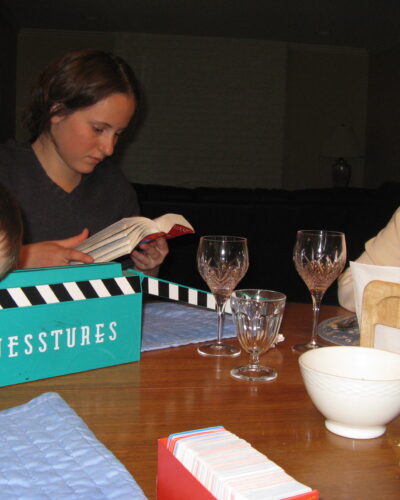 Family playing board game at dinner table.