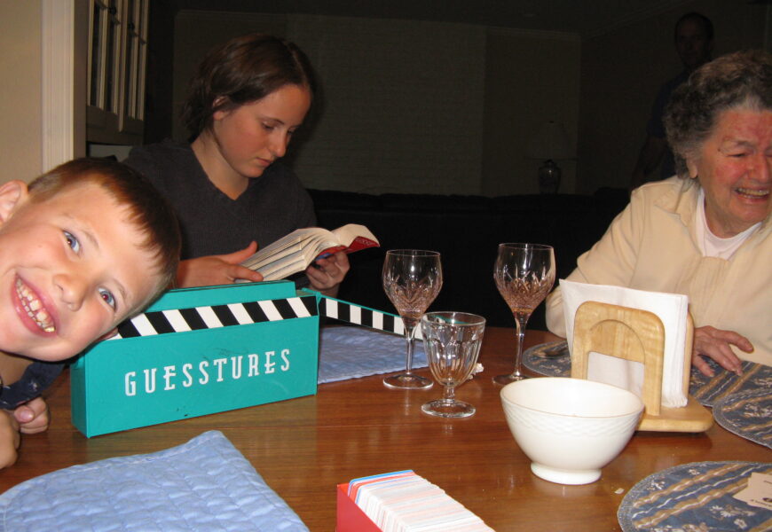 Family playing board game at dinner table.
