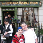 Children posing outside Sherlock Holmes Museum entrance.