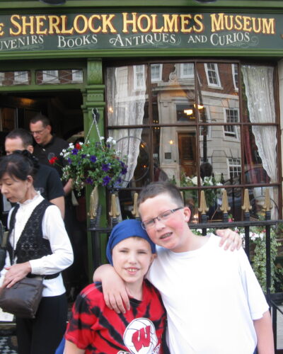Children posing outside Sherlock Holmes Museum entrance.