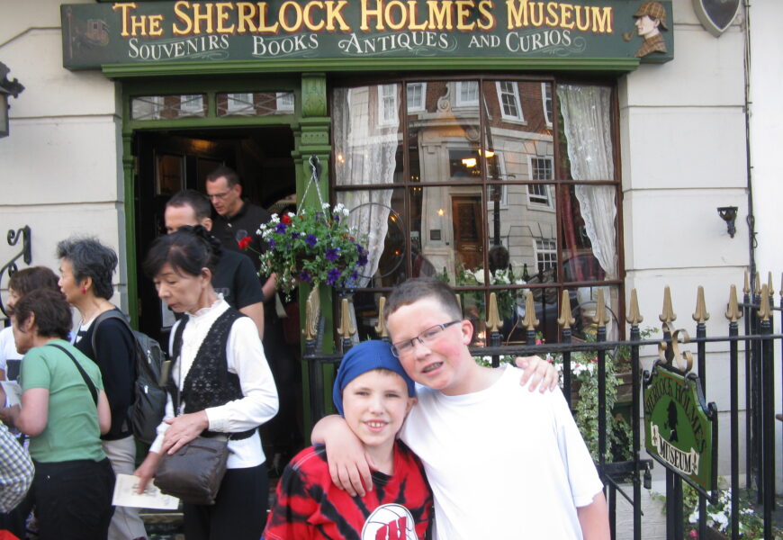 Children posing outside Sherlock Holmes Museum entrance.