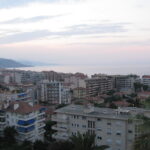 Coastal cityscape at dusk with ocean view.