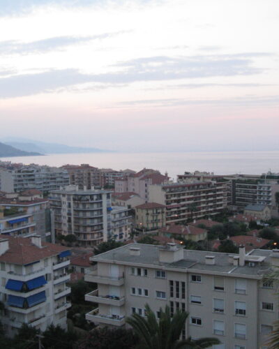 Coastal cityscape at dusk with ocean view.