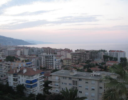 Coastal cityscape at dusk with ocean view.
