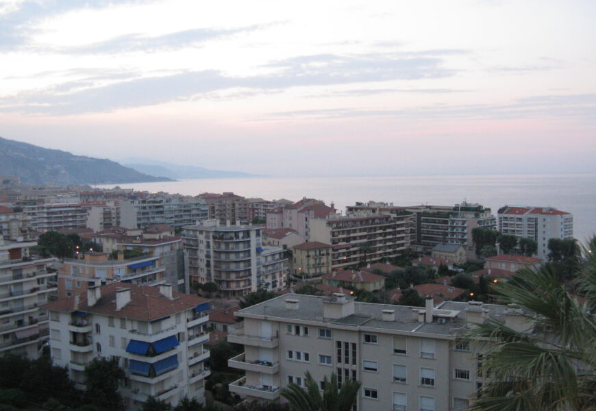 Coastal cityscape at dusk with ocean view.