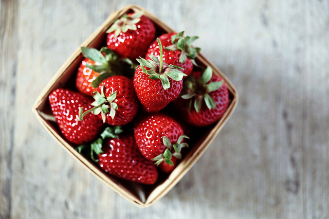 Basket of fresh red strawberries on table.