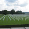 Military cemetery with rows of white crosses.