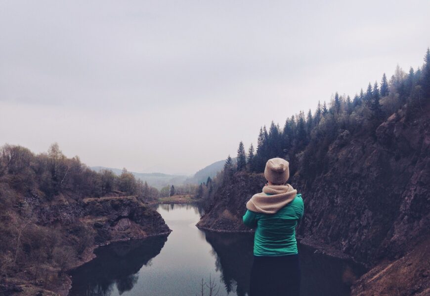 Person overlooking a serene mountain lake.