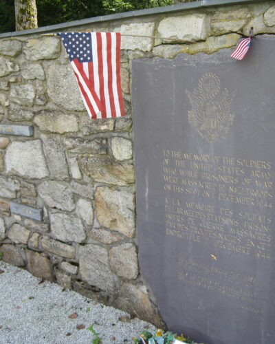 Memorial plaque with American flags on wall.