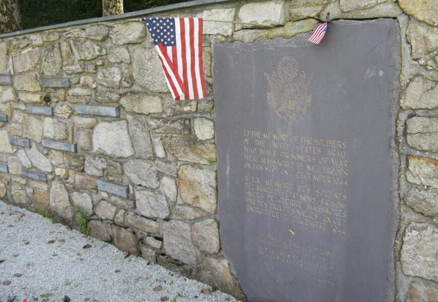 Memorial plaque with American flags on wall.